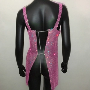 Dettaglio dell'abito rosa in maglia di strass con schiena scoperta e catene in metallo
