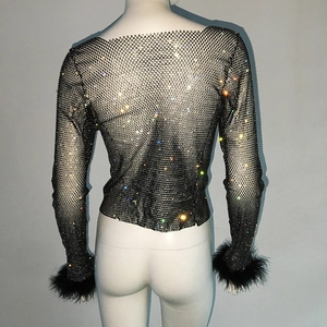 Detail of sequined mesh top featuring rhinestone inlay and black faux feather cuffs