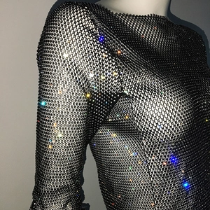 Detail of black mesh top with colorful rhinestones on collar and shoulder area