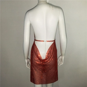 Gros plan sur la texture des paillettes rouges et la chaîne au dos de la robe de soirée