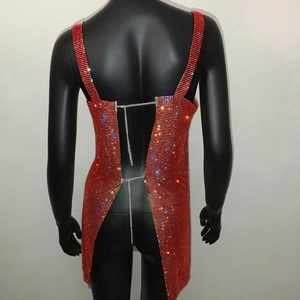 Dettaglio dell'abito da festa rosso con strass, schiena scoperta e catene metalliche