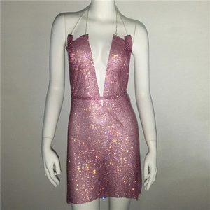 Détail d'une mini-robe rose en strass avec décolleté en V profond et fines chaînes en métal