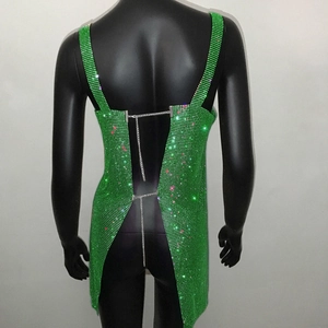 Dettaglio dell'abito verde con paillettes, catene in metallo argento e schiena scoperta