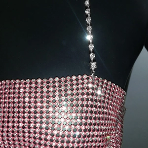 Macro shot of pink rhinestone mesh fabric and silver crystal straps for the party top
