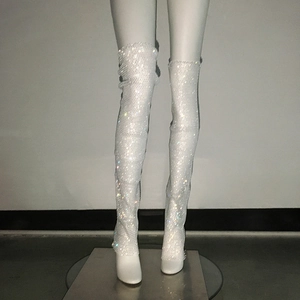 Détail de bottes cuissardes blanches à talons hauts avec cristaux scintillants