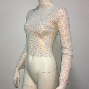 Detail of cropped mesh top featuring long sleeves and sparkling iridescent rhinestones