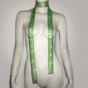 Detailed view of long green rhinestone scarf necklace on white display mannequin