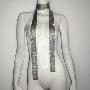 Detailed close-up of a long rhinestone choker necklace on a mannequin with glittering mesh