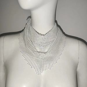 Détail d'un bandana en maille métallique blanche avec strass irisés sur un mannequin