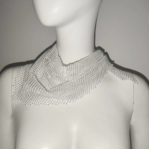 Détail du foulard en maille argentée avec strass brillants sur un mannequin buste