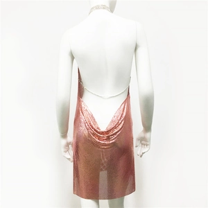 Détail d'une robe en maille métallique rose doré avec dos nu et chaîne en strass