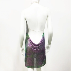Détail macro d'une robe dos nu en paillettes métalliques aux reflets violets et verts