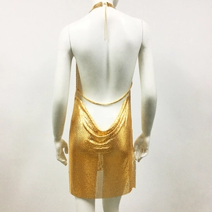 Detailed macro view of shimmering gold metal mesh fabric on backless party mini dress