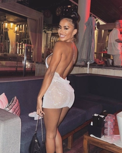 Close-up of white mesh mini dress with sparkling rhinestones and halter neck detail