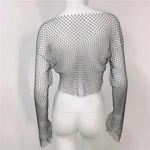 Detailed close-up of black mesh fabric with sparkling rhinestones on long sleeve top