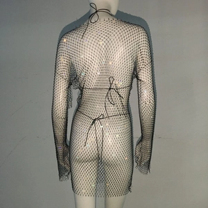 Detail of black rhinestone fishnet dress showing the mesh texture and back tie closure