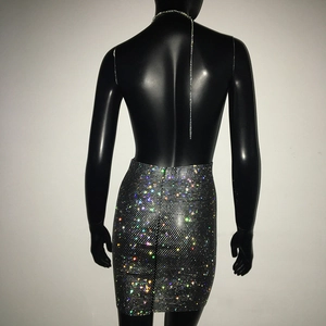 Detailaufnahme funkelnder Strasssteine auf schwarzem engem Kleid mit silberner Kette