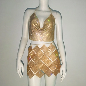 Détail de l'ensemble deux pièces en maille strass dorée avec top bénitier et jupe à sequins