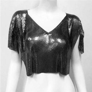 Dettaglio del crop top nero scintillante in maglia metallica con scollo a V e paillettes