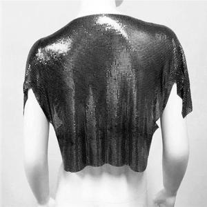 Dettaglio macro del tessuto in maglia metallica luccicante di un crop top di paillettes