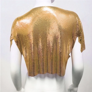 Dettaglio del top crop dorato in maglia metallica con paillettes e texture lucida