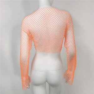 Macro detail of orange mesh crop top featuring shimmering rhinestones and fishnet texture