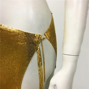 Détail d'une mini-jupe à paillettes dorées avec fermoir mousqueton réglable et chaîne
