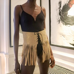Détail de ceinture dorée à franges en strass avec fermeture à lacets noirs ajustable