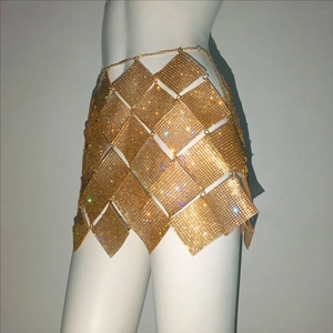 Vue détaillée de mini-jupe dorée en strass avec maillage métallique et chaîne de taille