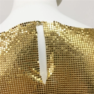 Détail de la maille à paillettes dorées avec fermoir mousqueton sur la zone du col