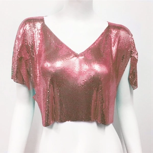 Dettaglio macro del tessuto con paillettes metalliche rosa su un crop top sexy con scollo a V