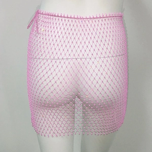 Détail de la mini-jupe rose en résille avec strass brillants et fermeture à lacets