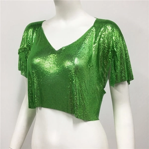 Dettaglio del crop top verde brillante con paillettes e trama metallica con scollo a V
