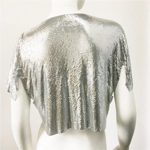 Dettaglio di un crop top in maglia metallica argento con paillettes lucide e trama traforata