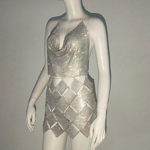 Détail macro du tissu en maille de strass argenté sur le haut court sexy et la mini-jupe