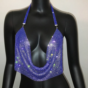 Dettaglio del top a lupetto con strass blu scintillanti, scollo a V e rete metallica