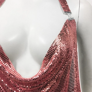Close-up of rose gold metal sequin chainmail fabric on a sexy V-neck party dress