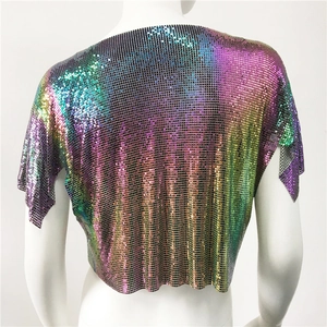 Dettaglio macro della trama di paillettes metalliche sfumate su un top festivo corto a V