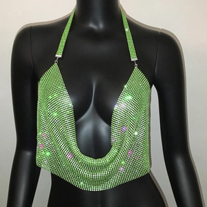 Dettaglio del top a lupetto verde neon scintillante con strass, scollo a V profondo e rete metallica
