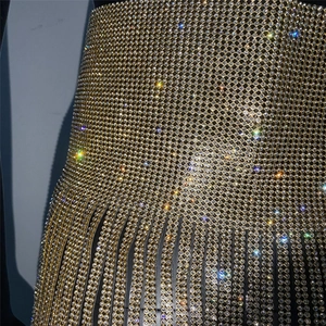 Dettaglio di strass dorati scintillanti e frange di nappe su questo top di lusso
