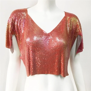 Dettaglio del crop top in maglia metallica con paillettes oro rosa e scollo a V