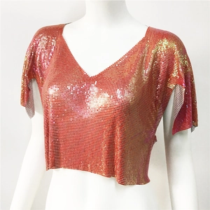 Dettaglio del crop top in maglia metallica con paillettes oro rosa e scollo a V profondo