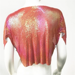 Dettaglio del tessuto a rete con paillettes metalliche e sfumatura arancio-oro sul retro