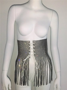 Détail de corset argenté en strass avec laçage croisé et longues franges métalliques