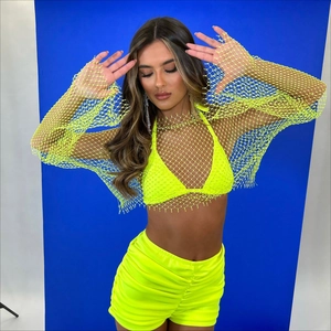 Detail of neon green fishnet long sleeve top with rhinestone accents and matching shorts set