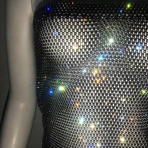 Gros plan du tissu en maille strass étincelant sur une mini robe bustier noire