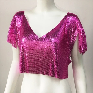 Dettaglio del crop top in maglia metallica con paillettes rosso rosa e scollo a V