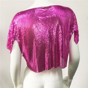 Dettaglio del crop top di paillettes rosa con texture a maglia metallica e scollo a V