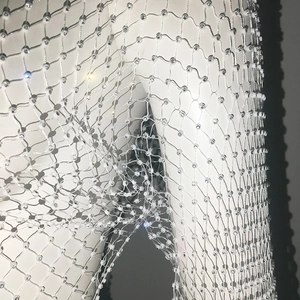 Close-up of white mesh top with shimmering crystals and intricate diamond weave detail