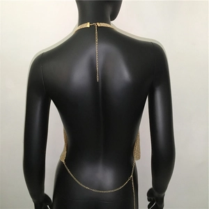 Dettaglio top in maglia metallica dorata con scollo all'americana e catena